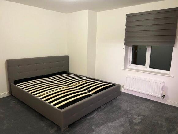 Bright, neutral double bedroom with a contempor...