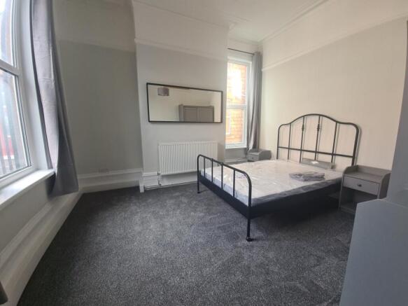 Bright double room with metal bed and bay windo...