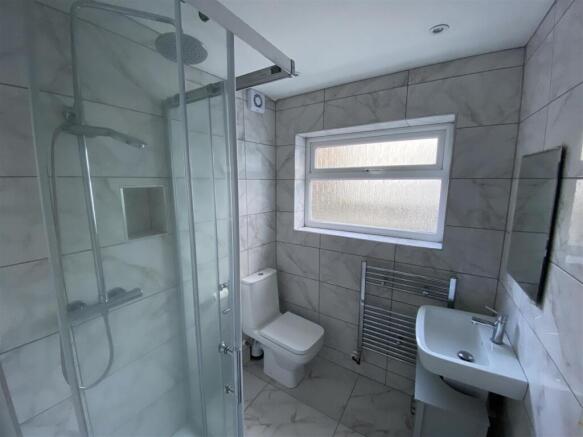Modern tiled bathroom with sleek rainfall showe...