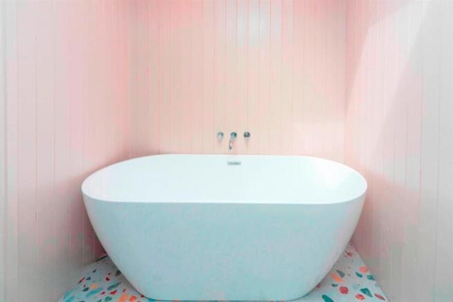 Stylish freestanding bathtub with pastel tiles...