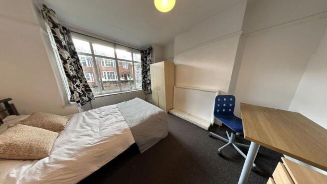 A cozy single bedroom with a large window provi...