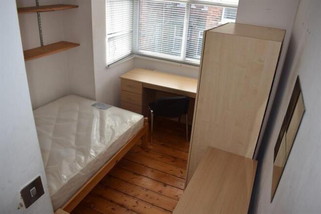 Bright, simply furnished bedroom with a single ...