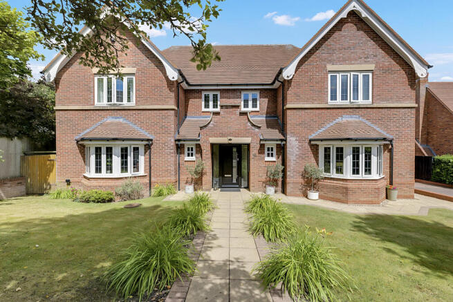 Front of house with driveway to the right - six cars can park plus double garage