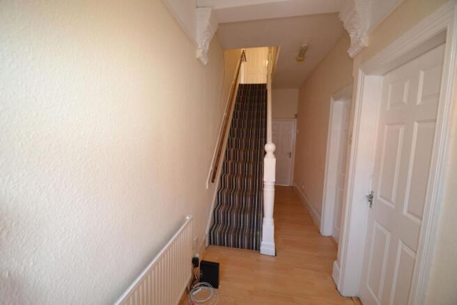 Bright, neutral hallway with wooden flooring, d...