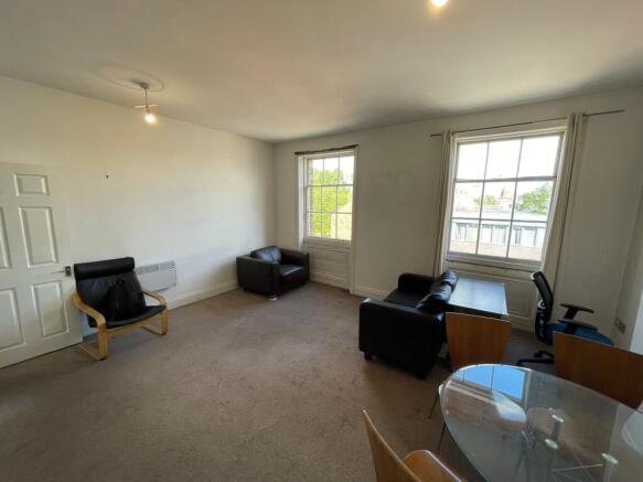 A bright living room featuring two large sash w...