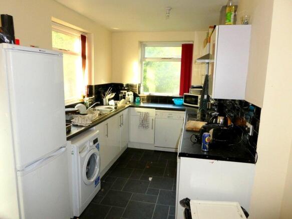 Bright, well-equipped kitchen with modern black...