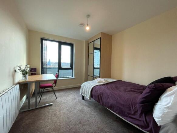 Bright and cozy single bedroom featuring a larg...