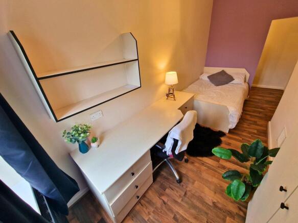 Bright, neatly furnished single bedroom with a ...