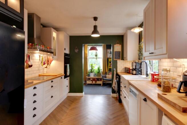 View of kitchen with large range and into family r