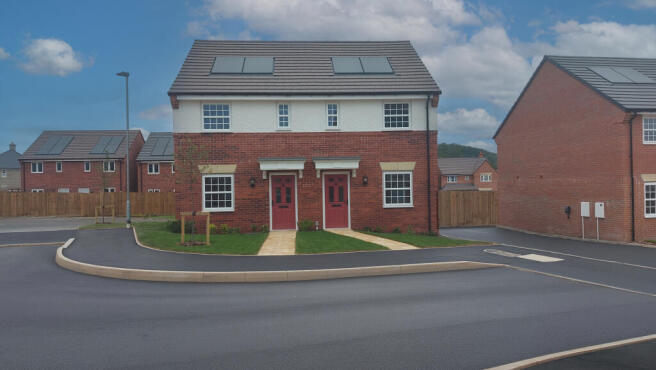 A newly built semi-detached house with red doors and white windows stands on a paved road in the for