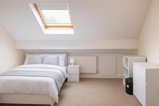 Bright attic bedroom with stylish skylight...