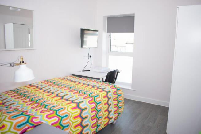 Bright bedroom with desk and modern furnishings...