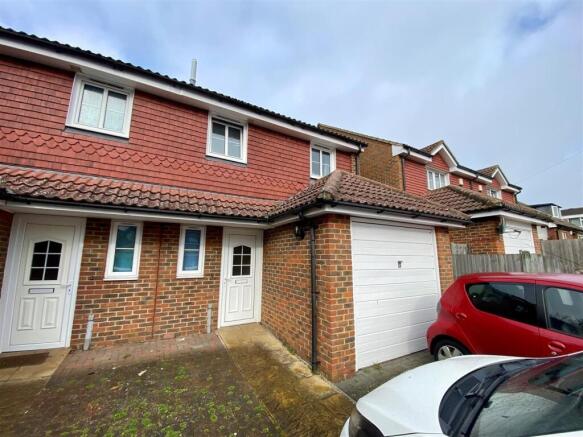 Terraced house frontage with garage and parking...