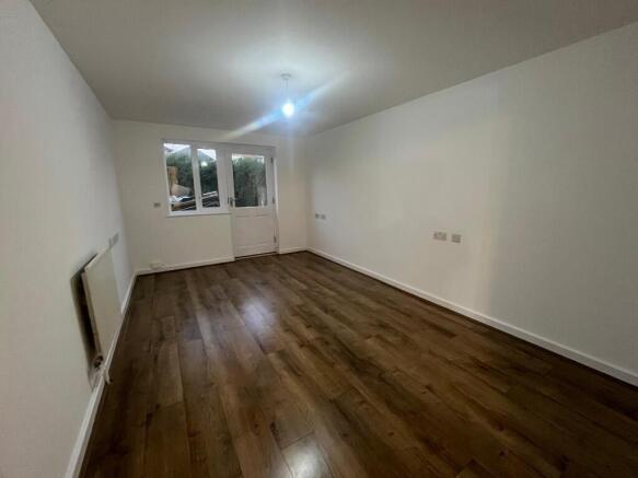 Bright long living room with wood flooring...