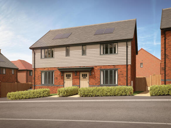 A row of modern semi-detached houses with manicured hedges in the foreground and a clear blue sky in