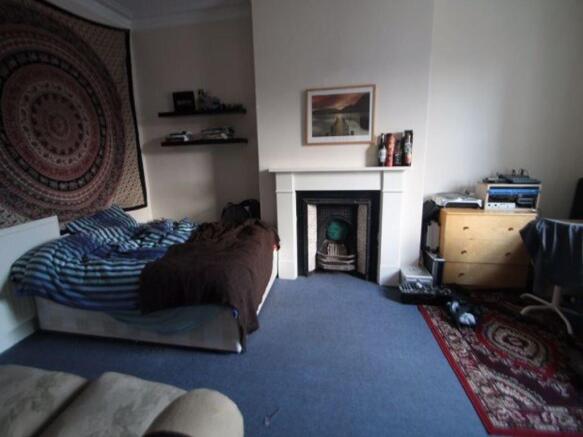 A spacious master bedroom featuring a comfortab...