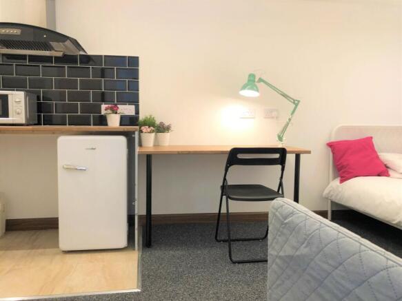 A neat and well-lit student bedroom corner feat...