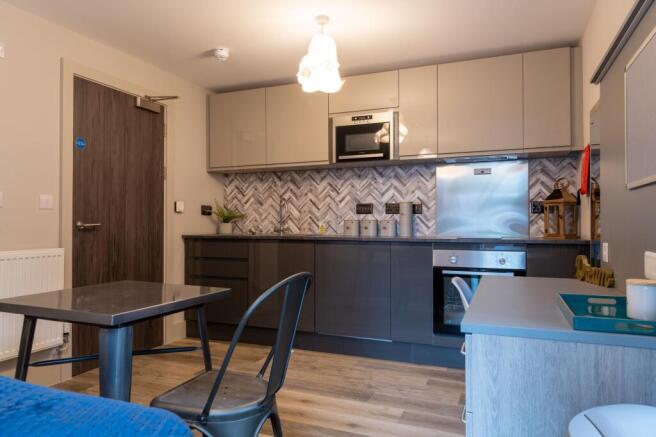 Modern kitchen area with sleek grey cabinetry, ...