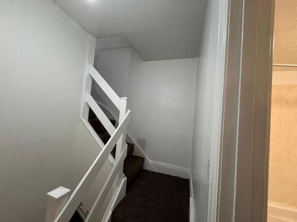 Compact painted staircase with carpeted steps...