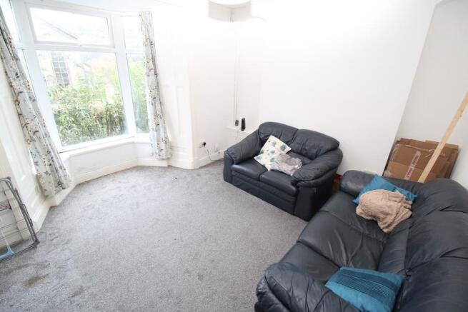 Bright lounge with bay window and leather sofas...