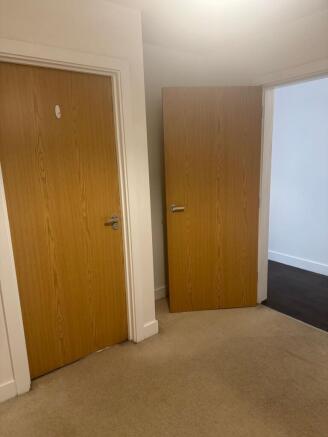 Bright, neutral hallway with wooden doors...
