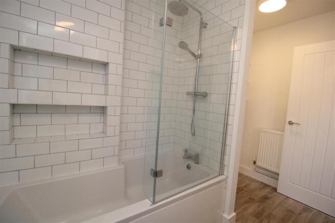 Modern bathroom with subway tiles and deep bath...
