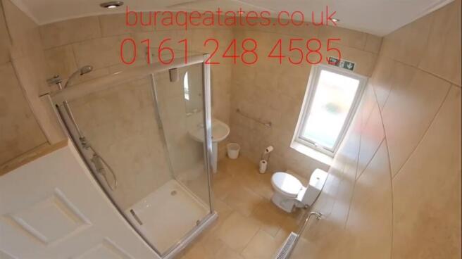 Bright, modern tiled bathroom with a glass-encl...