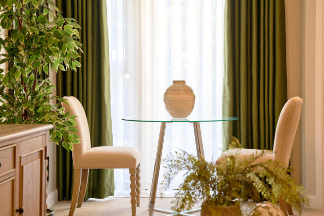 a chair and a plant in a room with a window