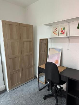 A well-organized student room featuring a wardr...