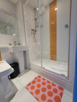 Bright, modern bathroom with a glass-enclosed s...