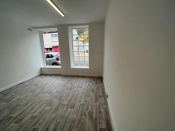 Bright living area with stylish wood flooring...