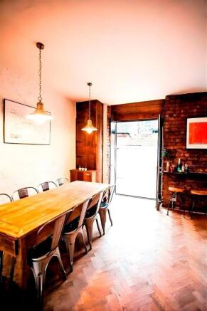 Bright dining area with long wooden table...