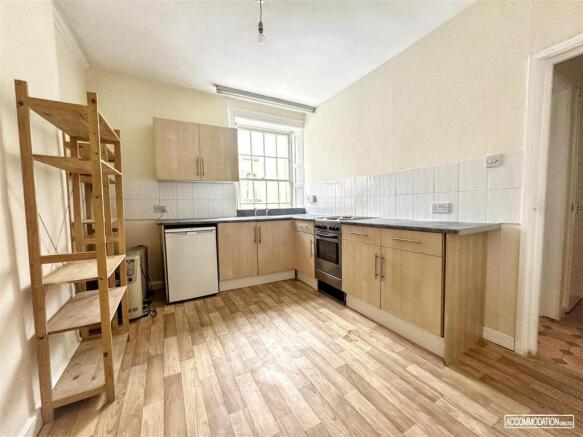 Bright kitchen with fitted units and wood floor...