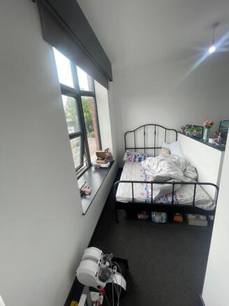 A bright single bedroom featuring a large windo...