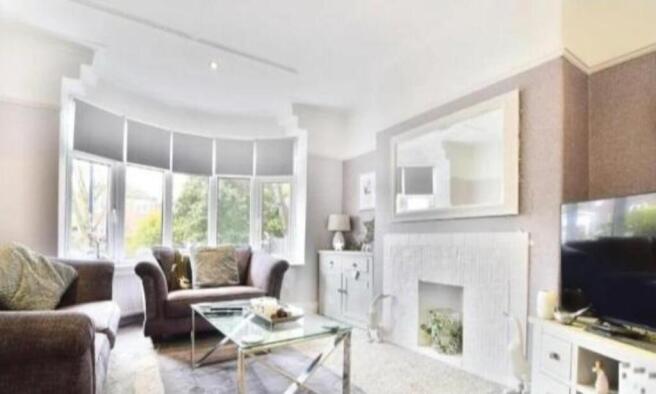 Bright lounge with a bay window and fireplace...
