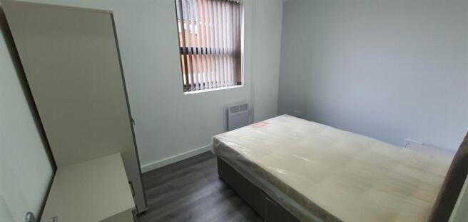 Bright, simply furnished bedroom with a full ma...