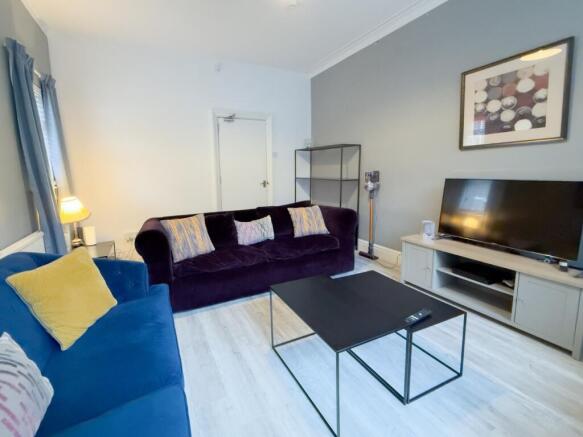 Bright living room with modern sofas and TV...