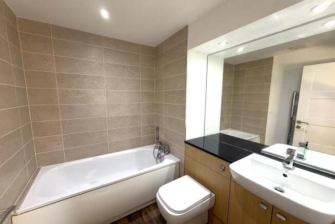 Modern bathroom suite with full-sized bathtub...