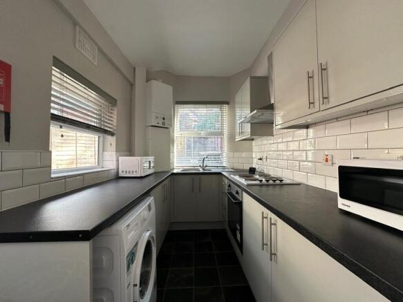 Modern galley kitchen with sleek tiling...