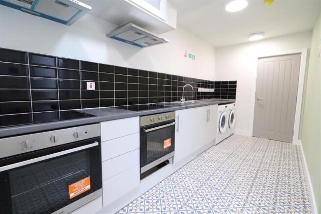 Bright modern galley kitchen with tiled floorin...