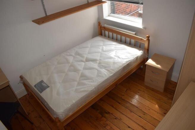 Bright, simply furnished bedroom with a double ...