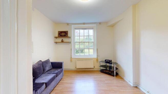 Bright lounge with plush sofa and wood flooring...