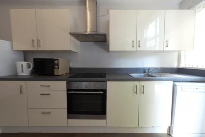 A clean and modern kitchen with ample counterto...