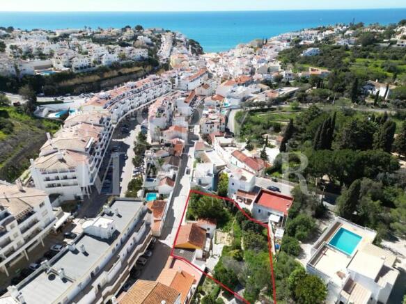 Aerial view of land plot for sale in Carvoeiro center, Algarve. Real estate investment opportunity with approved project for luxury apartments near the beach.