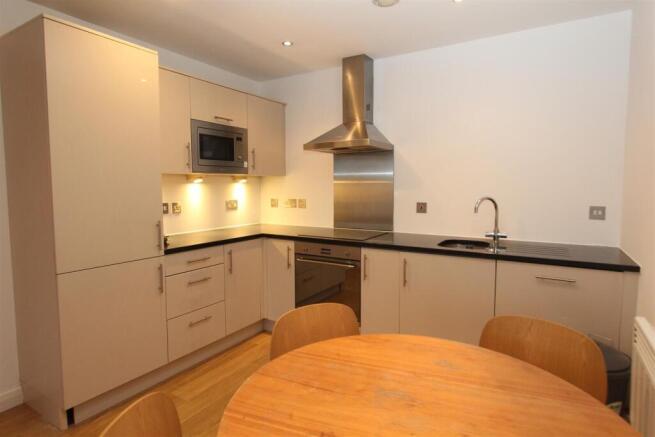 Modern kitchen with sleek units and dining area...