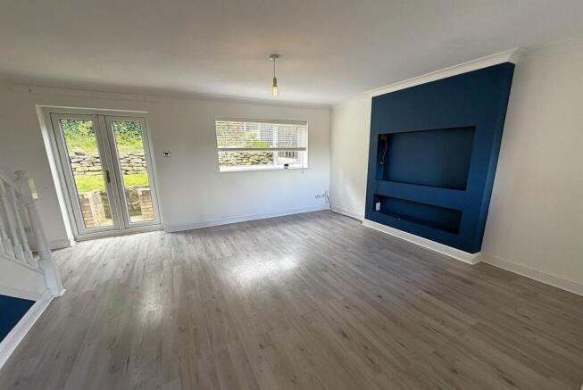 Bright, modern living area with stylish blue wa...