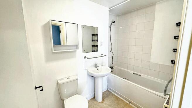Bright bathroom with full tub and mirror cabine...