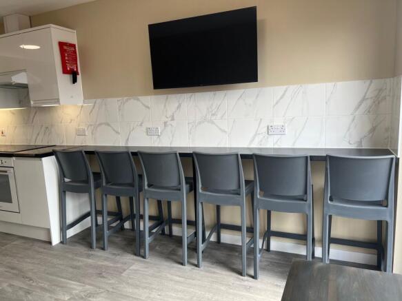 Modern kitchen area featuring a row of five dar...