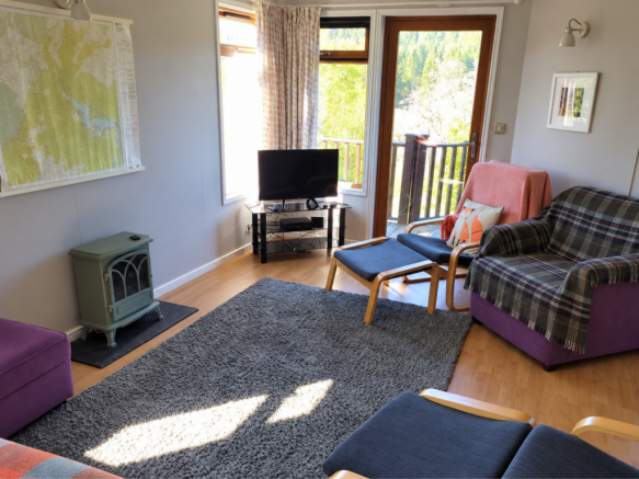 Bright lodge lounge with doors opening onto the de