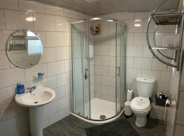 Bright, modern bathroom with a curved glass sho...